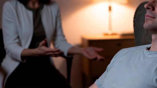 Терапевт гипнотизирует расслабленного пациента
